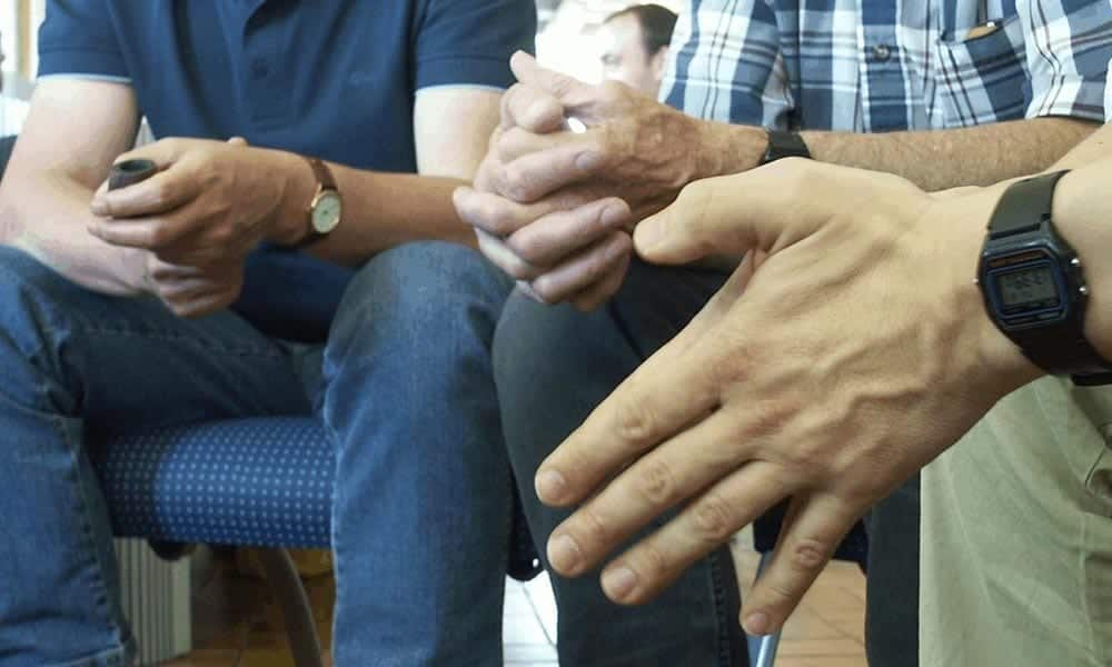Photo of family members sitting in circle.