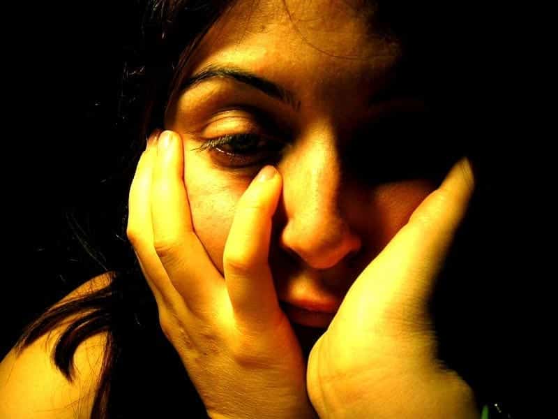 Photo of depressed woman.|Photo of a stack of newspapers.